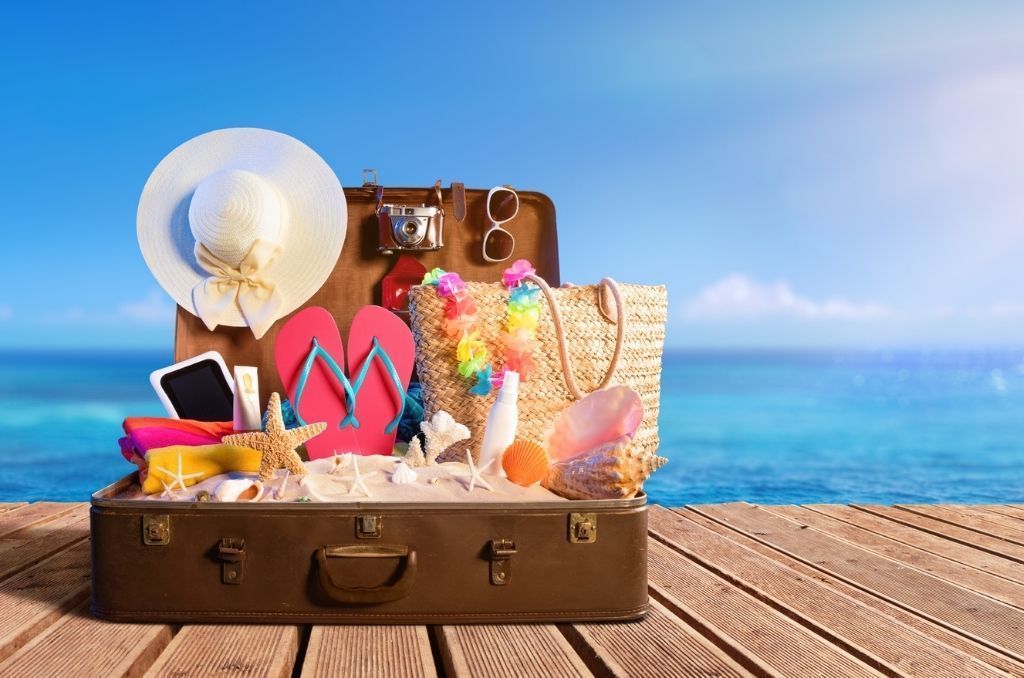 Maleta organizada con ropa y accesorios esenciales para viaje a la playa