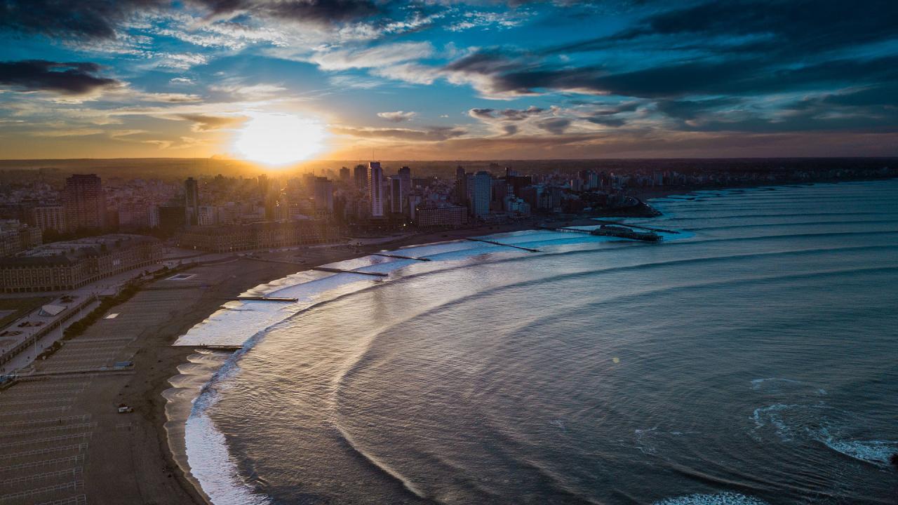 Espectacular vista aérea de Mar del Plata durante el atardecer mostrando la costa dorada