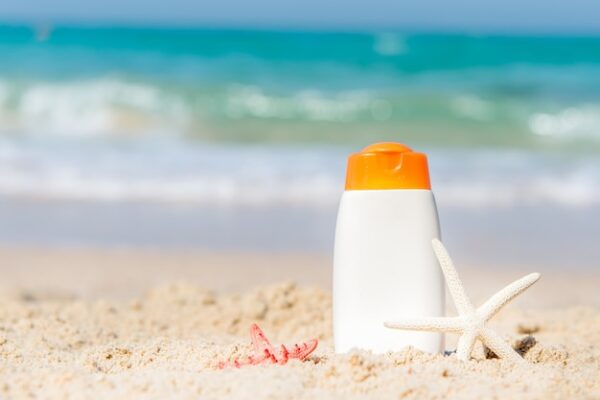 Protector solar en la playa con accesorios de verano